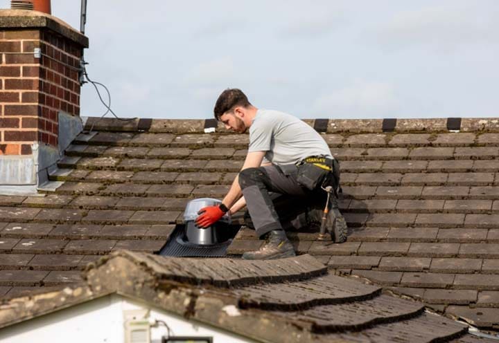 A man installing a Solatube light tunnel on a roof